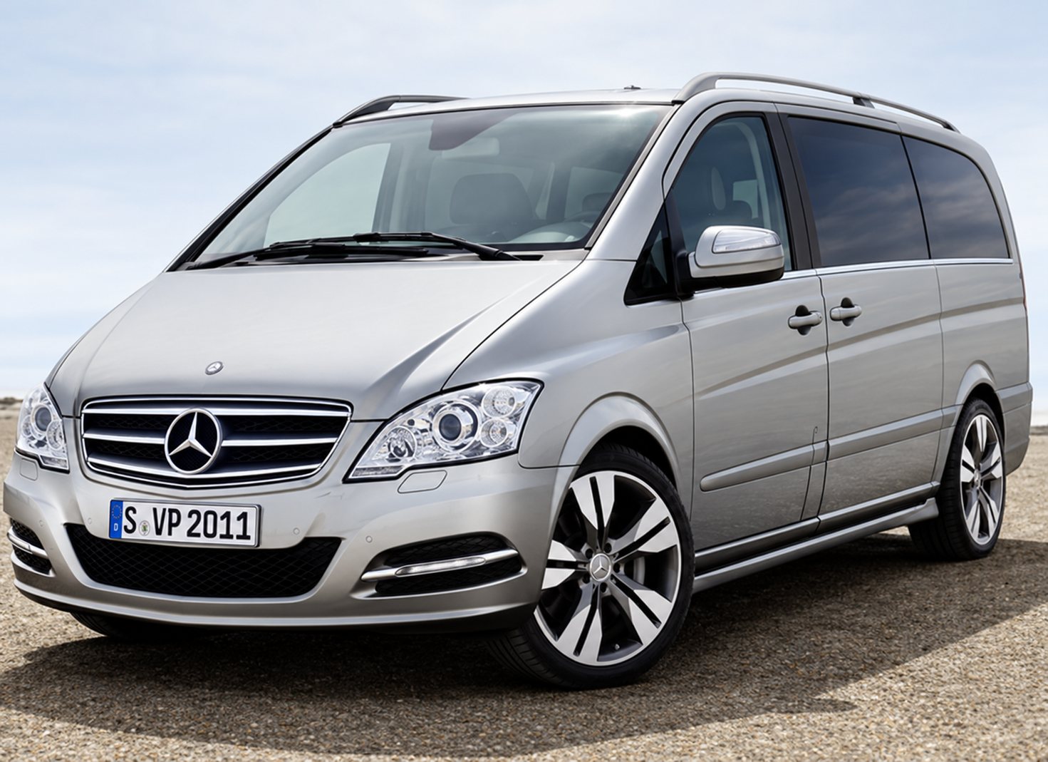 Un monospace Mercedes gris métallisé photographié de trois quarts avant, avec sa calandre à étoile et ses jantes alliage, devant un fond neutre.